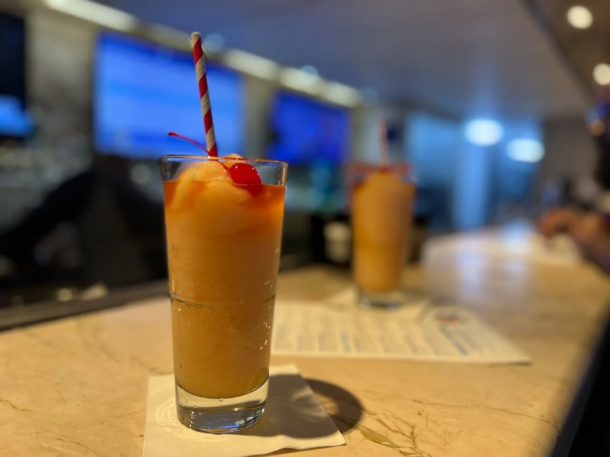 Tropical cocktail with cherry and striped straw at Margaritaville Paradise bar