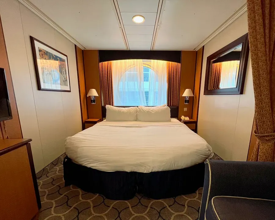 Ocean View room interior on Brilliance of the Seas, showing a double bed and port hole