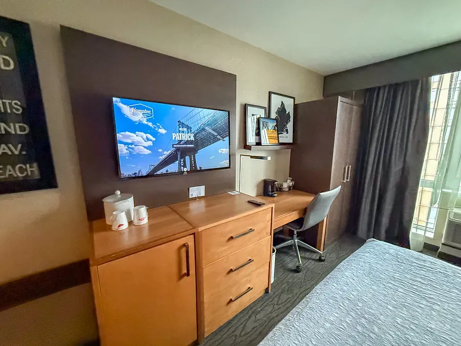 Hampton Inn Brooklyn hotel room desk area with wall-mounted TV and workspace