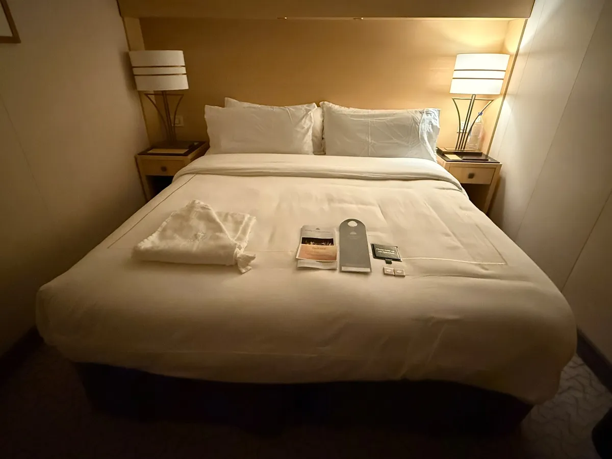 Inside cabin on Queen Mary 2 with king-size bed and bedside lamps