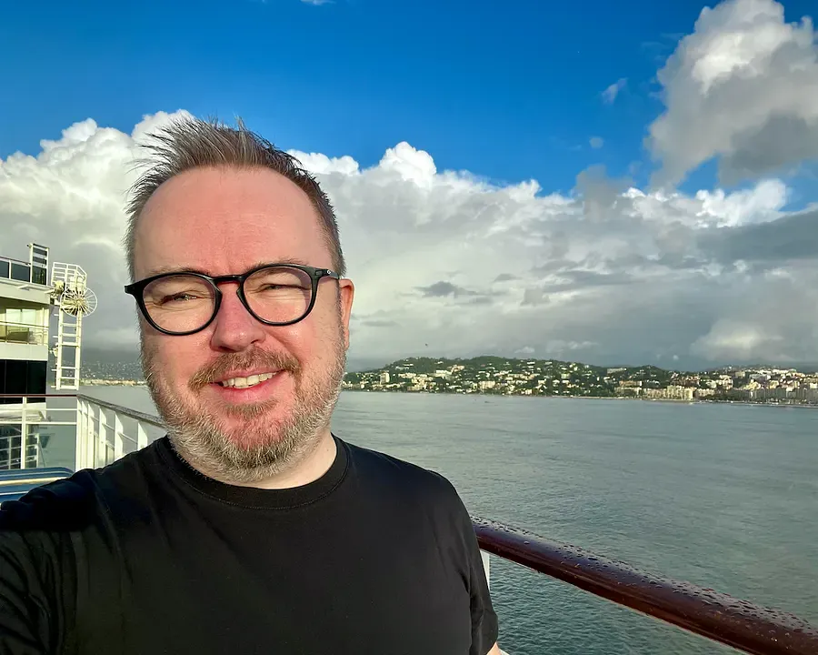 Patrick Hughes aboard the Norwegian Epic cruise ship with Cannes in the background 