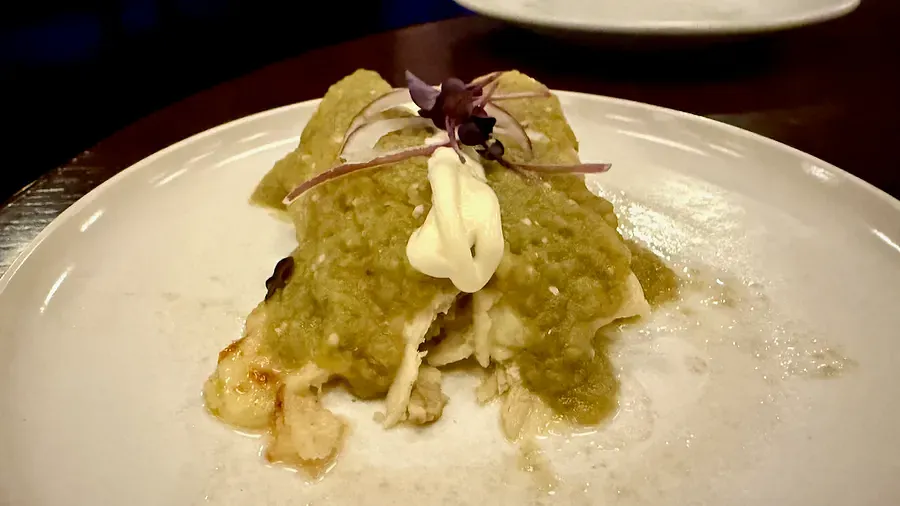 Chicken Enchiladas topped with a green mole sauce 