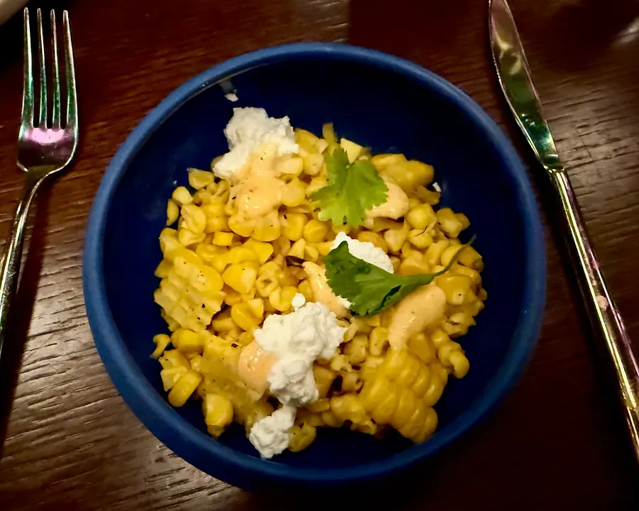 A bowl of sweetcorn with cheese and other flavours