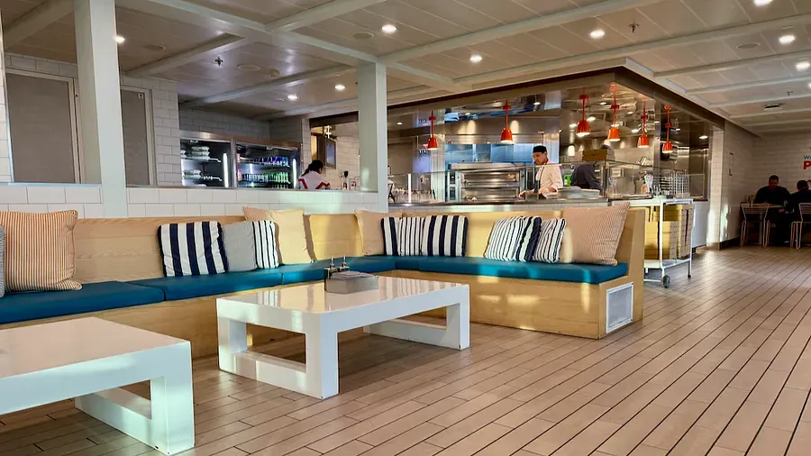 Comfortable seating at the Pizza Place on Scarlet Lady with striped soft cushions