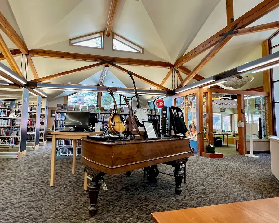 Interior of Skagway Public Library featuring a large walnut piano