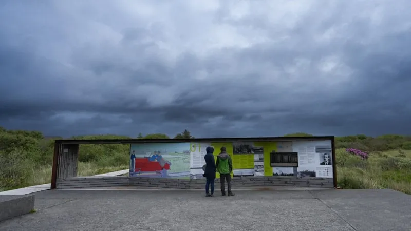Two visitors reading the interpretative signs along the Derrygimlagh loop walk