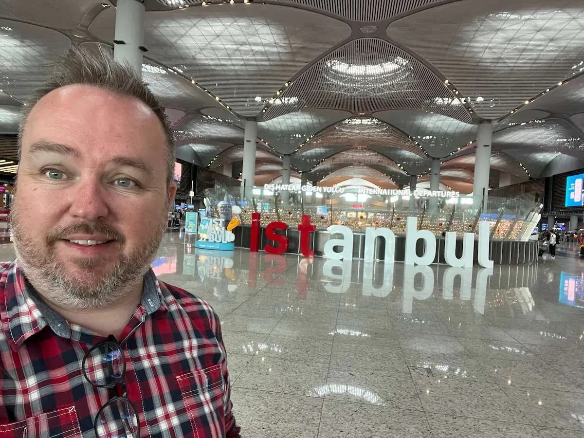 Flight reviewer, Patrick Hughes, in front of an Istanbul sign at Istanbul Airport