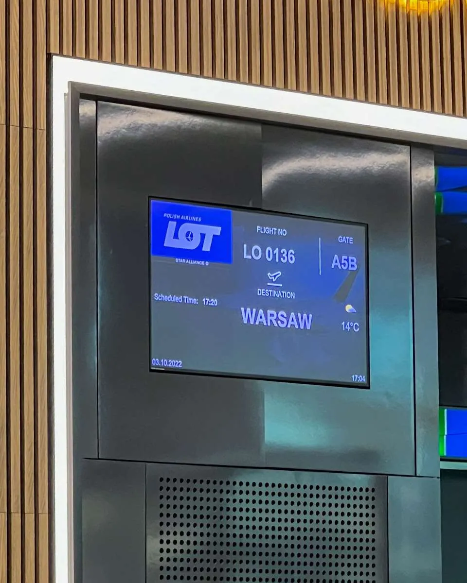 An electronic sign reading Destination: Warsaw at Gate A5B at Istanbul airport. 