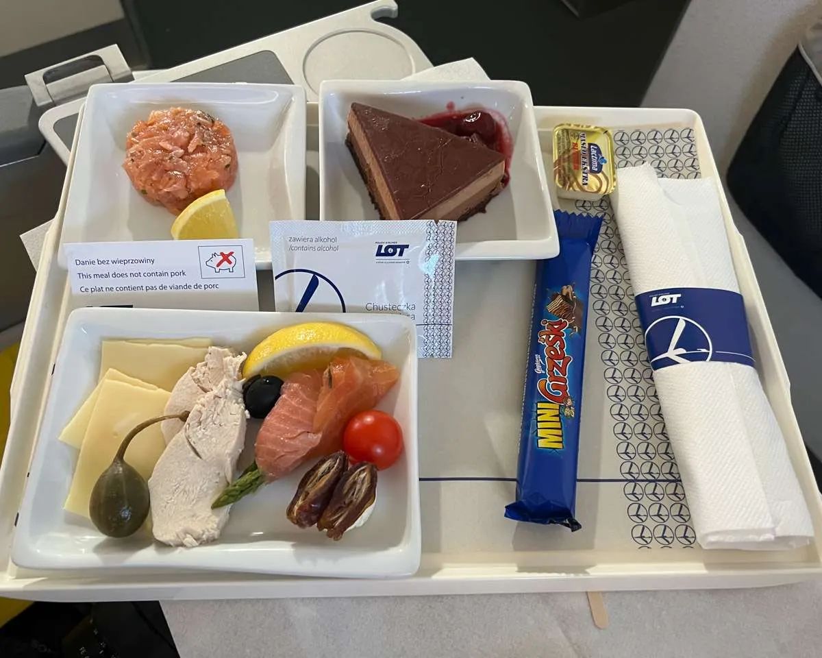 The food tray on LOT Polish Airlines, featuring a cold salad, smoked salmon and a chocolate mousse cake. 