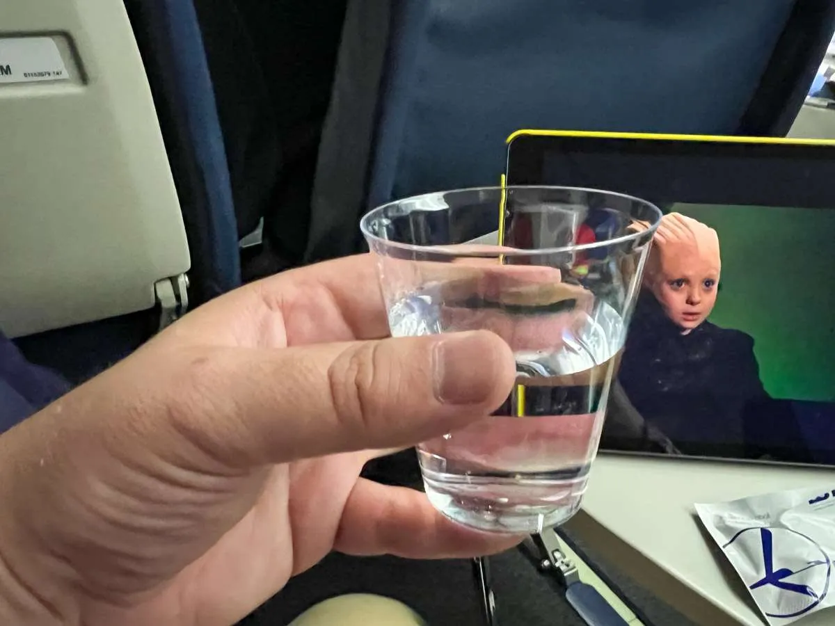 Patrick holds up a glass of water. 