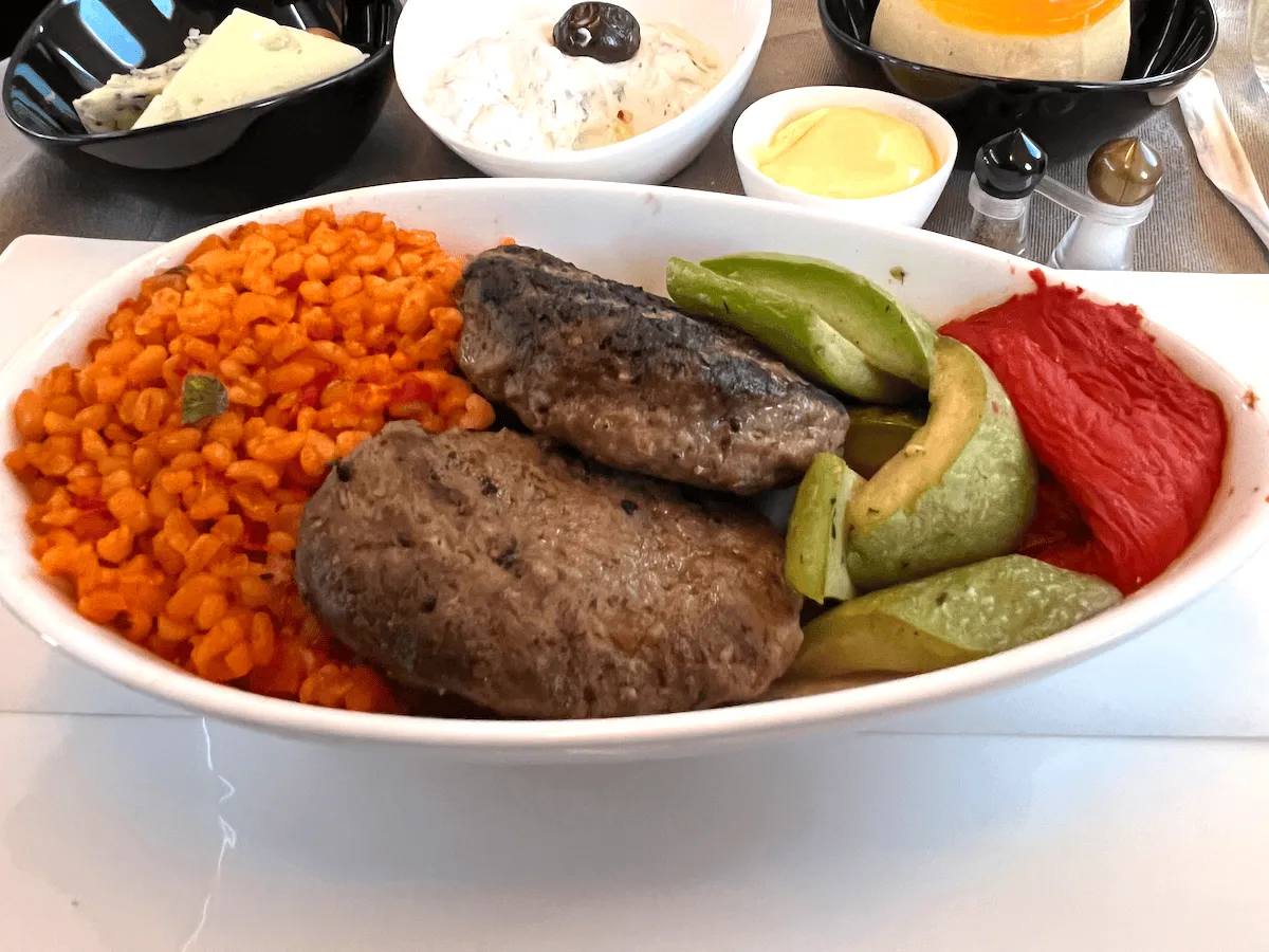 A plate of typical Turkish meatballs with bulgur wheat and vegetables 