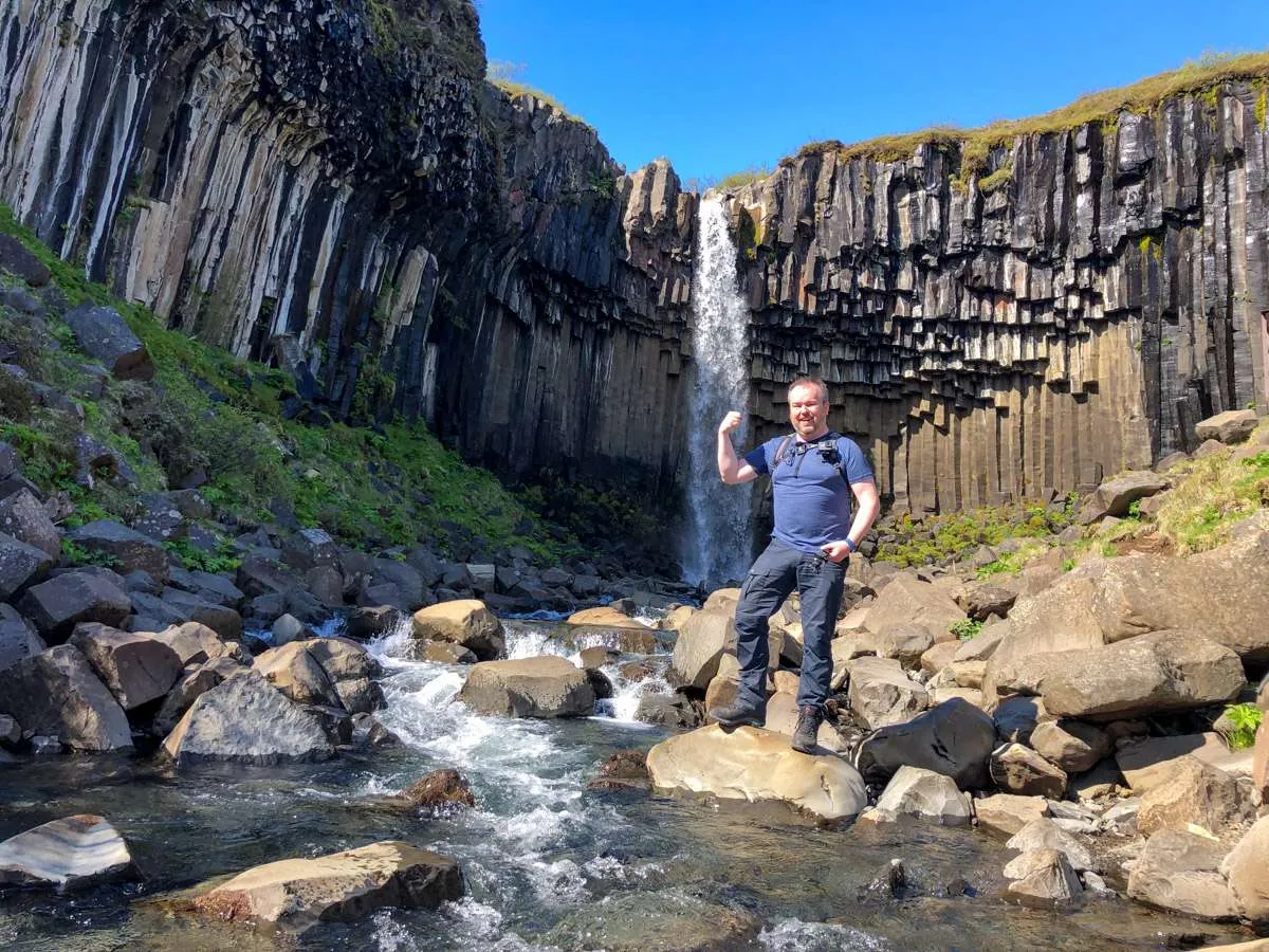 A beautiful waterfall in Iceland, Patrick standing mid-frame