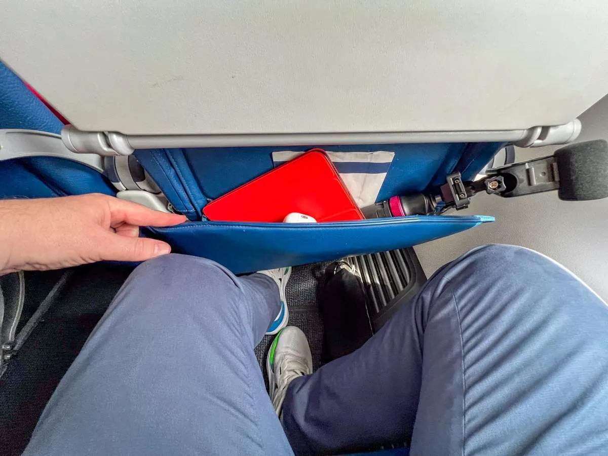 An airline passenger showing how much legroom there is