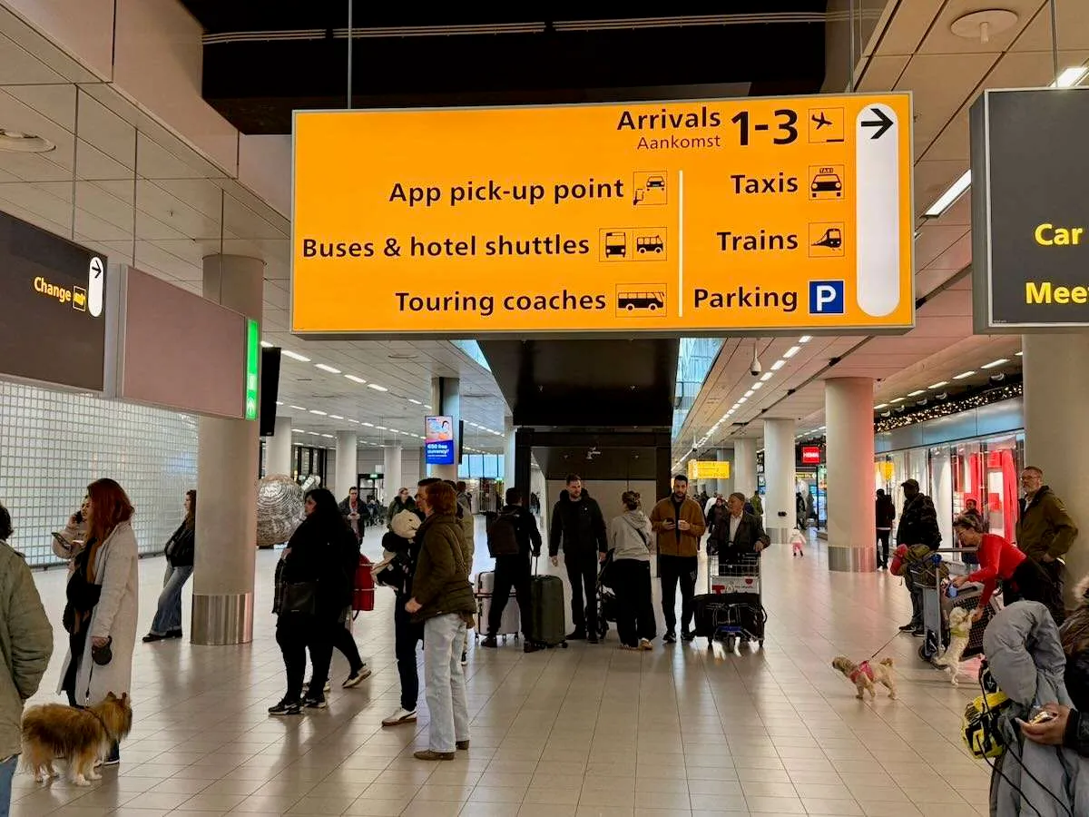 A large yellow overhead sign at Schiphol Airport