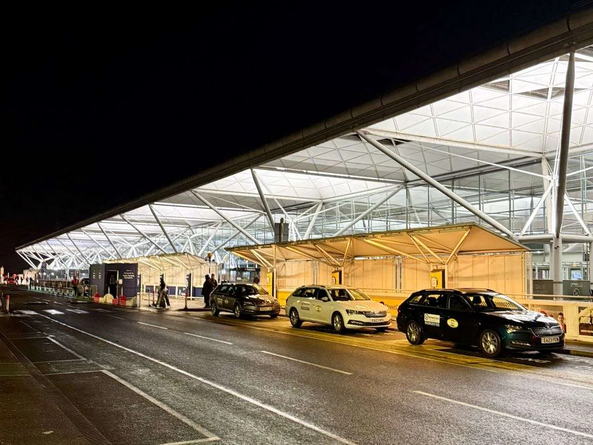 taxis wait outside Stansted Airport at night