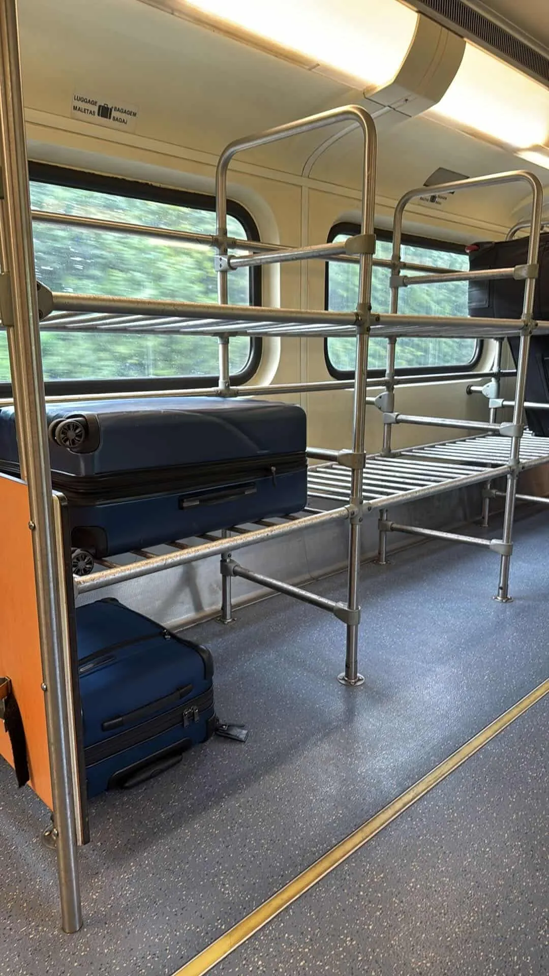Two suitcases on a luggage rack on the Tri-rail train