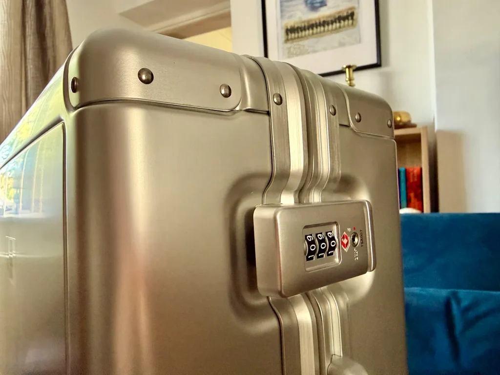 Silver aluminum suitcase with TSA-approved combination lock in hotel room