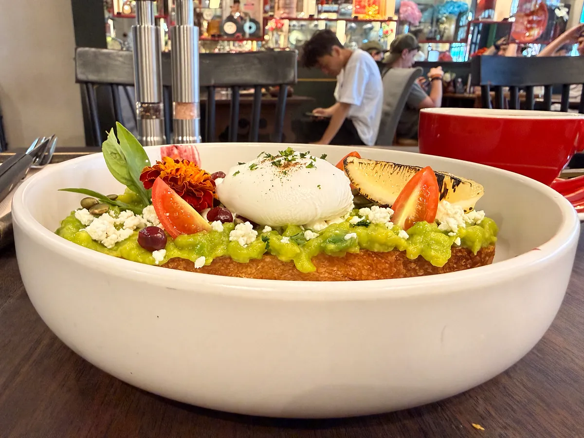 Avocado toast with egg, tomato, and edible flowers at a cafe in Phuket Old Town