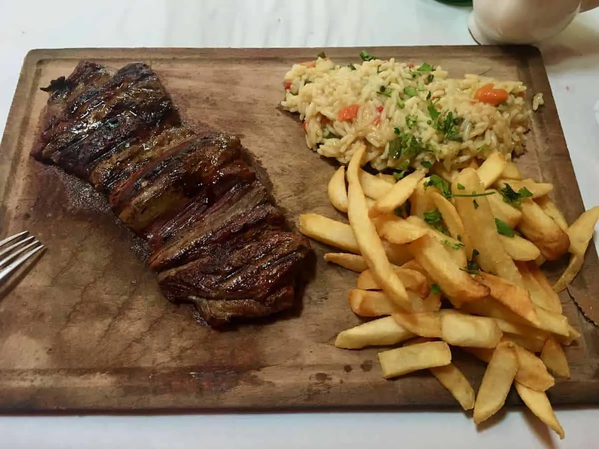 A steak and chips on a wooden board in Palermo Buenos Aires